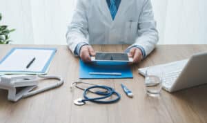 doctor utilizing healthcare IT support at his desk
