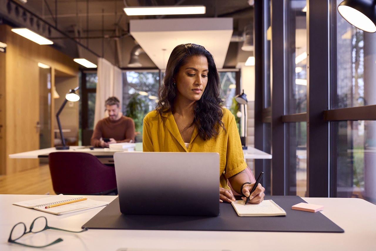 female business woman researching cybersecurity insurance coverage at her desk