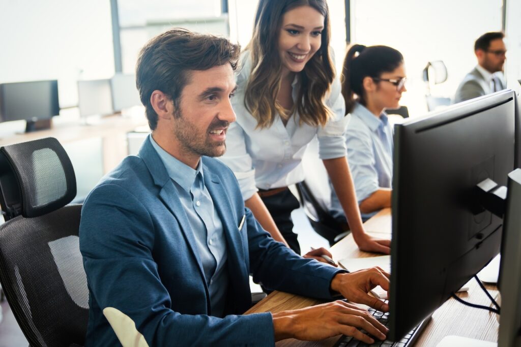 coworkers in office working on computer together