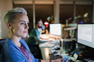 business employees working in office on computers next to each other